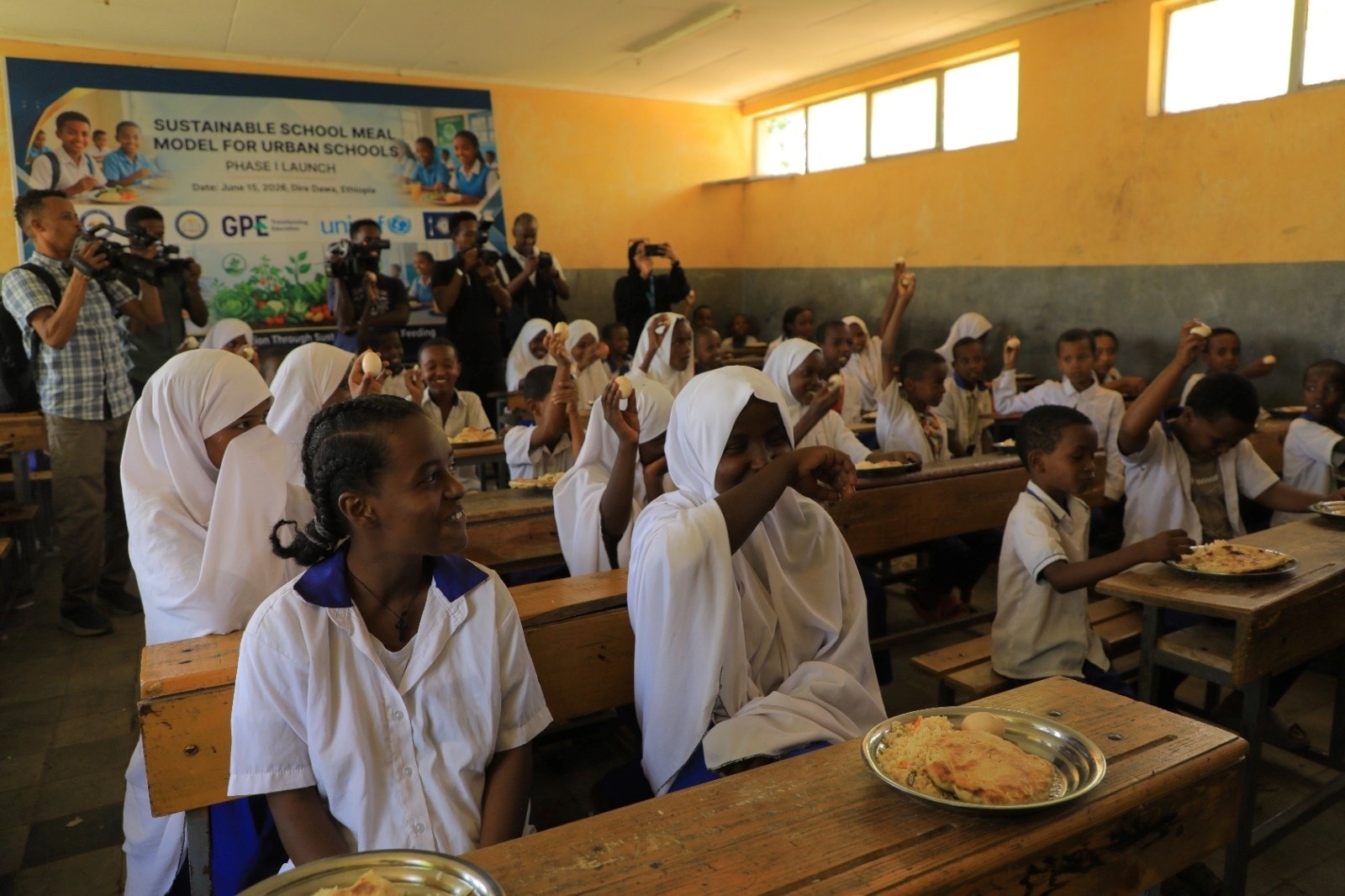 Children and ESMI leadership together at a school